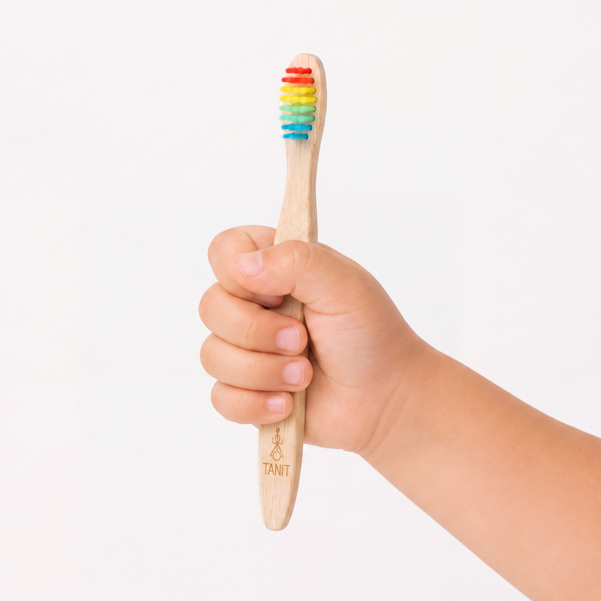 A child holding a Rainbow kids bamboo toothbrush